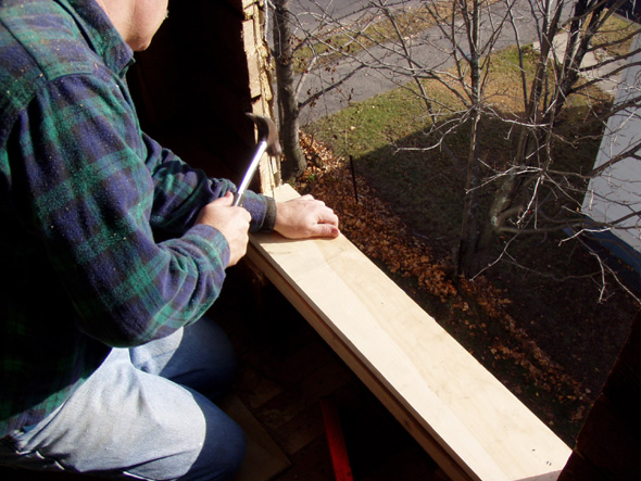 The bottom of the window sill is being put into place.