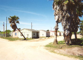 Inexpensive housing units, located along Fletcher Street at Mateo Escobar.  Fletcher Street, running diagonally in a northwest/southeast direction, was built along the path of the abandoned railroad tracks.
